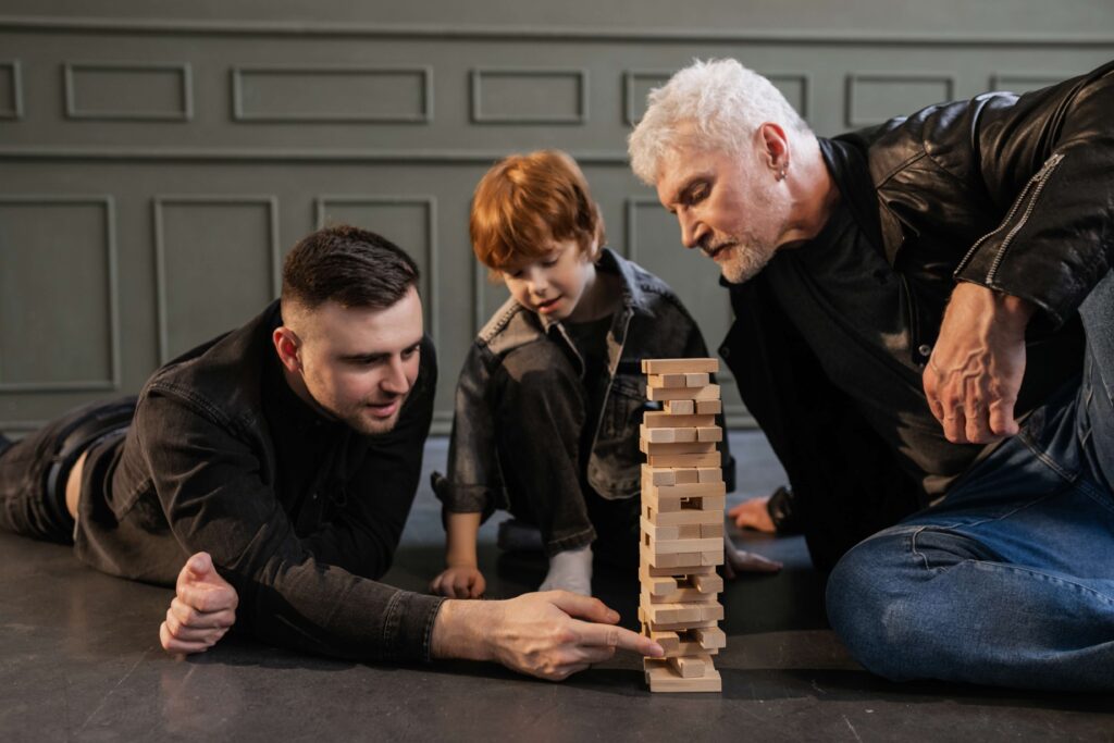 An elderly man, a young man, and a little boy playing Jenga - lennon lawyers - estate planning lawyers